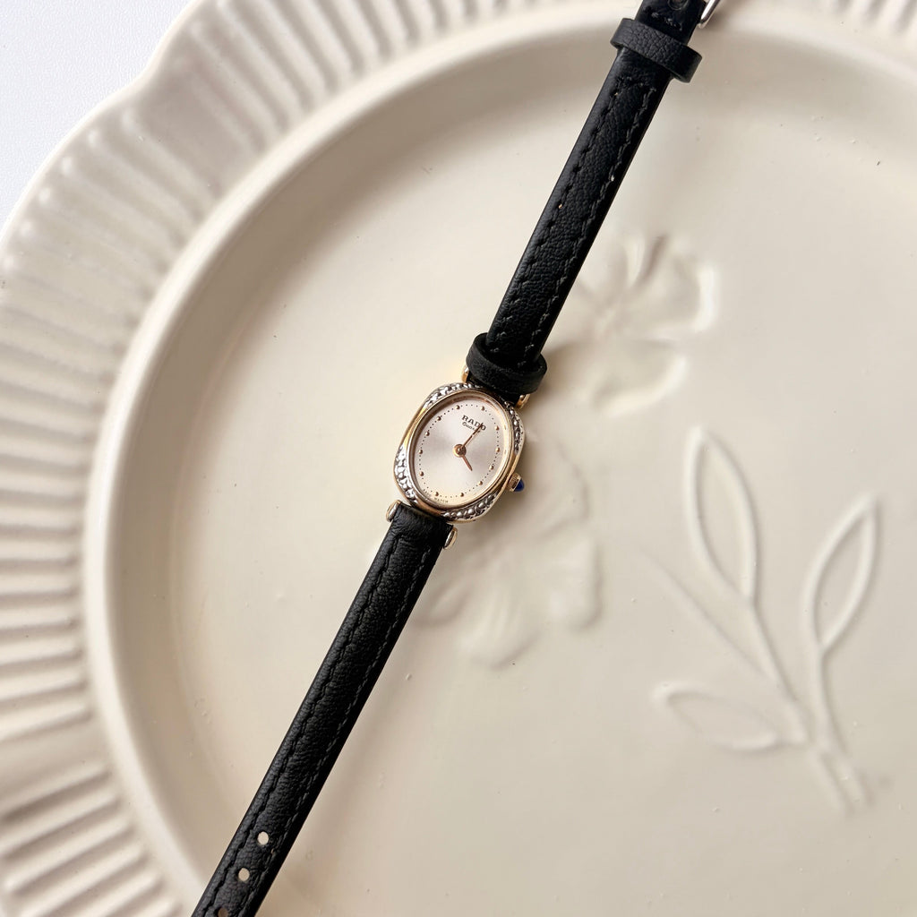 Rd. Gold Oval White Jewel Dial with Black Strap Watch