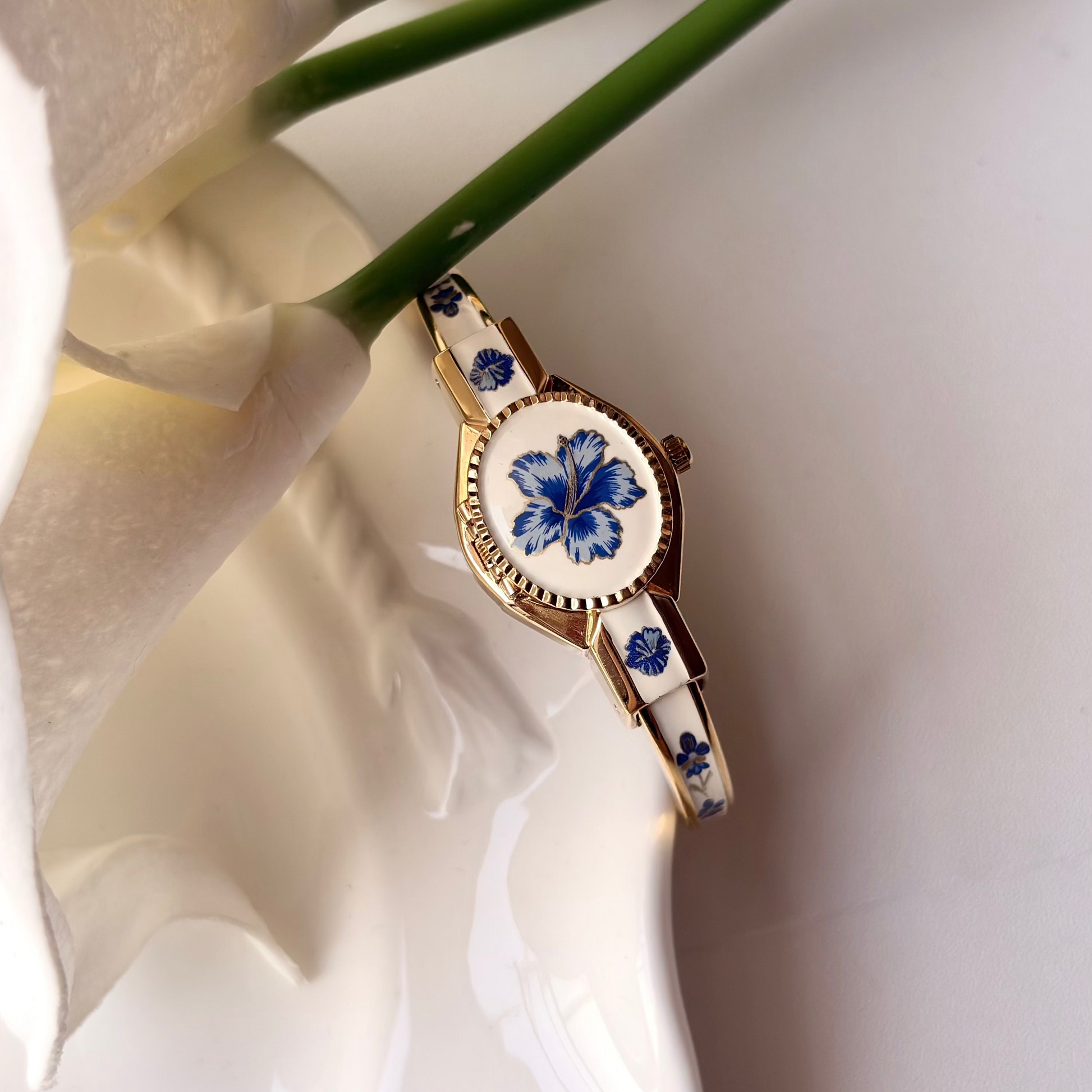 AM. White Blue Flower Case Gold Bangle Watch